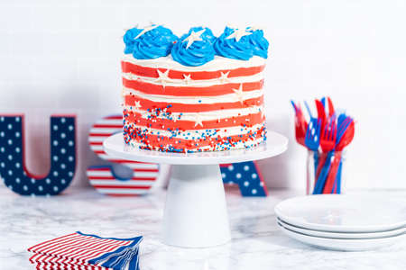 Decorating chocolate cake with white, red, and blue buttercream frosting for July 4th celebration.の写真素材