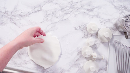 Flat lay. Step by step. Rolling our white fondant on a marble counter.