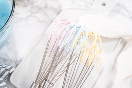 Mixing food coloring into the meringue to bake unicorn meringue cookies.