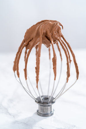 Whiped chocolate ganache on a whisk of kitchen mixer.の写真素材