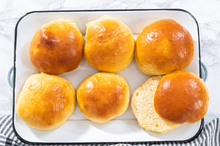 Freshly baked brioche buns on a metal serving tray.の写真素材