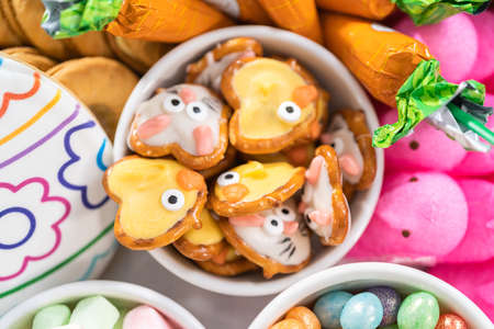 Assembling charcuterie board with Easter candies, cookies, and marshmallows.の写真素材