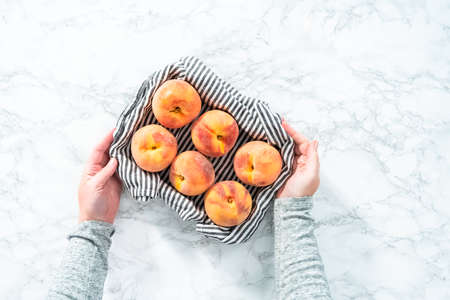 Organic whole peaches in a metal wired basket.の写真素材