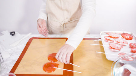 Step by step. Peeling cooled homemade lollipops from silicone baking mats.