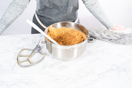 Mixing ingredients in standing kitchen mixer to bake peanut butter cookies.