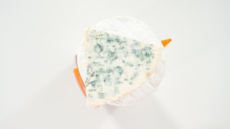 Flat lay. Large slice of gourmet cheese on a white background.の写真素材