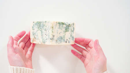 Flat lay. Large slice of gourmet cheese on a white background.の写真素材