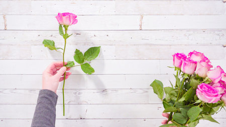 Flat lay. Fresh pink roses on a wooden background.