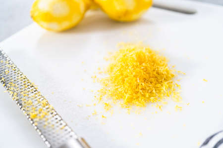 Zesting organic lemons to bake a lemon pound cake.の写真素材