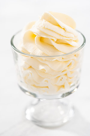 Homemade whipped cream in a class ice cream bowl.の写真素材