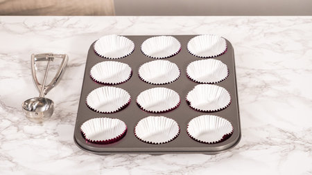 Step by step. Baking chocolate cupcakes. Lining metal cupcake pan with foil cupcake liners.