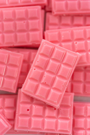 Homemade mini pink chocolates in a food glass container.