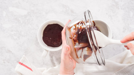 Flat lay. Step by step. Pouring chocolate cake batter into the cups to prepare chocolate mug cake.の写真素材