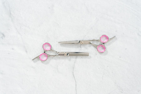 Flat lay. New barber pink scissors on a gray background.