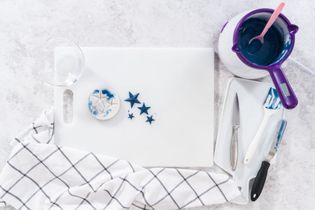 Flat lay. Filling star-shaped silicone mold with melted color chocolate.
