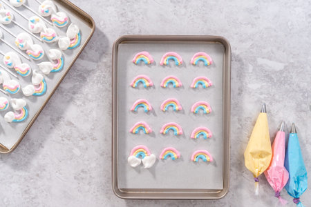 Flat lay. Unbaked unicorn theme meringue pops on a baking sheet lined with parchment paper.
