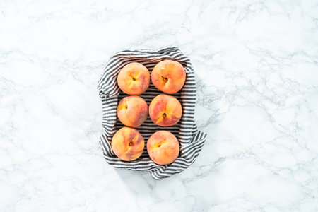 Organic whole peaches in a metal wired basket.の写真素材