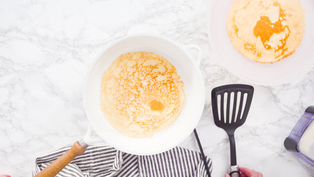 Flat lay. Making crepes in a small frying pan over medium heat.の写真素材