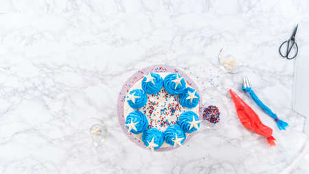 Flat lay. Decorating chocolate cake with white, red, and blue buttercream frosting for July 4th celebration.の写真素材