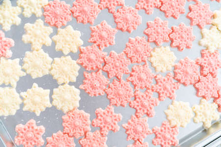 Chocolate shaped like small snowflakes on a baking sheet.の写真素材