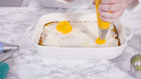 Piping rosettes with Italian buttercream frosting on top of sheet cake.の写真素材