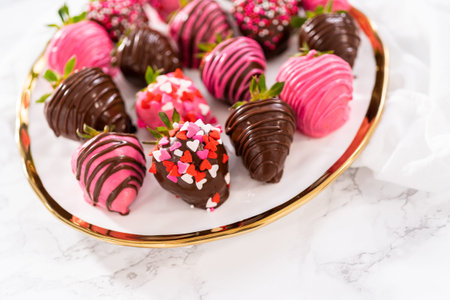 Gourmet chocolate-covered strawberries decorated with chocolate drizzles and sprinkles on a white...