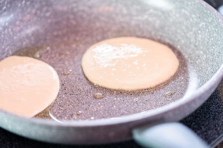 Frying small pancakes on a kefir base in a frying pan.の写真素材