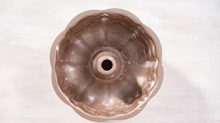 Step by step. Flat lay. Greased metal bundt cake pan to bake chocolate bundt cake with chocolate frosting.の写真素材