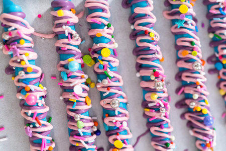 Mermaid chocolate pretzel rods drizzled with pink and purple chocolate and covered with sprinkles.の写真素材