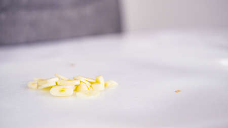 Curring vegetables on a white cutting board to cook vegetarian white bean soup.の写真素材