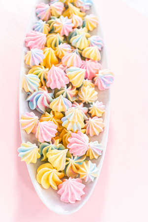 Multicolored unicorn meringue cookies on a white serving plate.の写真素材