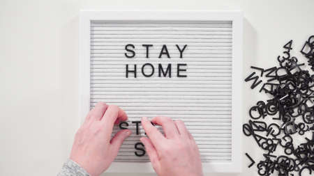 Flat lay. STAY HOME and STAY SAFE sign on a white message board.の写真素材