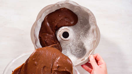 Step by step. Flat lay. Chocolate cake batter in a metal bundt cake pan ready for baking.の写真素材