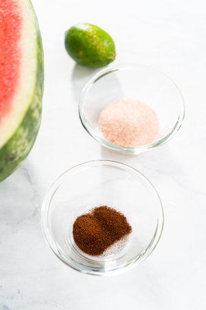 Measured ingredients in a small glass mixing bowl to prepare chili lime watermelon pops.