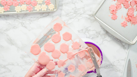 Flat lay. Step by step. Pouring melted chocolate into a plastic chocolate mold in the shape of...