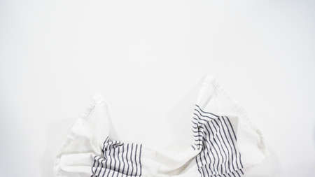 Flat lay. White and black kitchen towel on a white countertop.の写真素材