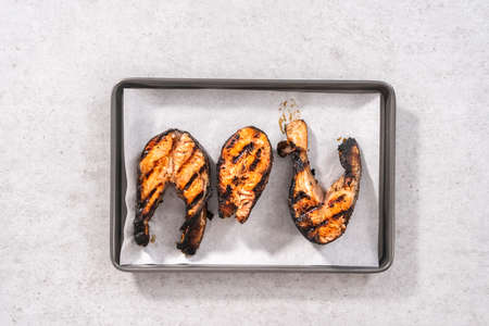 Flat lay. Grilled salmon steaks on a baking sheet with parchment paper.の写真素材