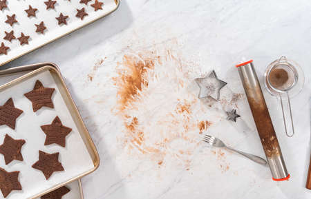 Flat lay. Cutting star-shaped chocolate graham crackers from the dough with a cookie cutter.の写真素材