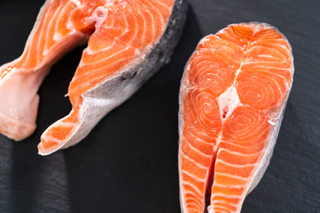 Farm-raised salmon steaks on a slate board.の写真素材