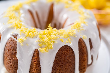 Lemon bundt cake decorated with lemon zest on a cake stand.の写真素材
