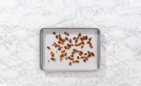 Spreading organic pecans on a baking sheet lined with parchment paper to make toasted pecans.