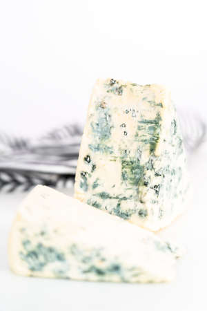 Large slice of blue cheese on a white background.の写真素材