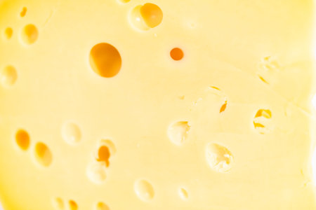 Large slice of semi soft part skim cheese on a white background.