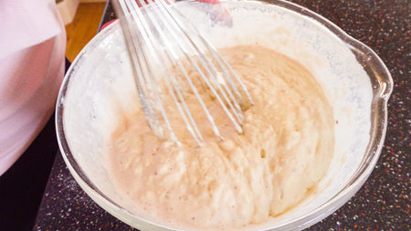 Mixing ingredients in a glass mixing bowl to make homemade pancakes.