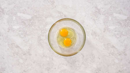 Flat lay. Step by step. Mixing ingredients in a glass mixing bowl to prepare coconut banana pancakes.の写真素材