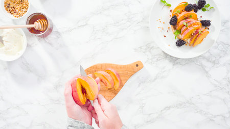 Flat lay. Step by step. Slicing organic peach to make a ricotta and peach toast on ciabatta bread.