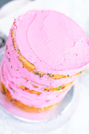 Funfetti cake layers with pink buttercream frosting.の写真素材