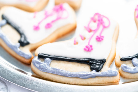 Decorating sugar cookies shaped as figure skates with royal icing.の写真素材