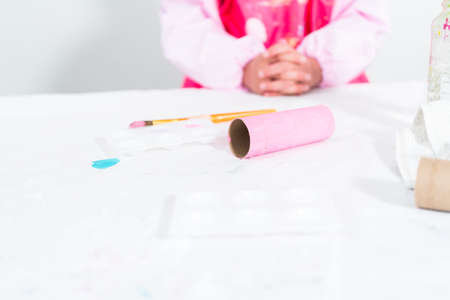 Little girl making a unicorn out of the toilet paper roll and craft paper.の写真素材
