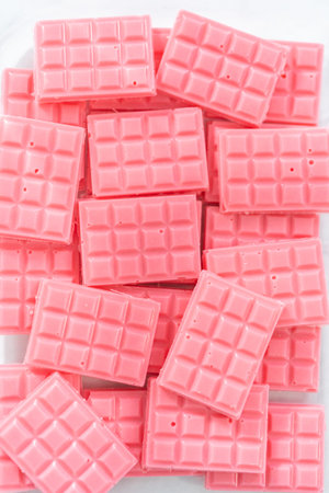 Homemade mini pink chocolates in a food glass container.